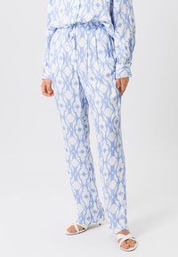 Lichtblauwe broek met een abstract wit patroon, elastische tailleband en een losse pasvorm. De stof is glad met een lichte glans.