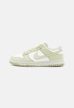 Light green and white Nike Dunk sneakers with leather upper, round toe, perforated detailing, and textured rubber sole.
