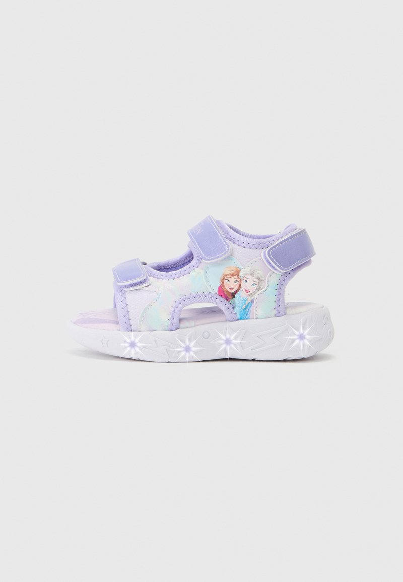 Light purple sandals with adjustable straps, featuring a graphic design of two female characters. The sole has light-up accents.