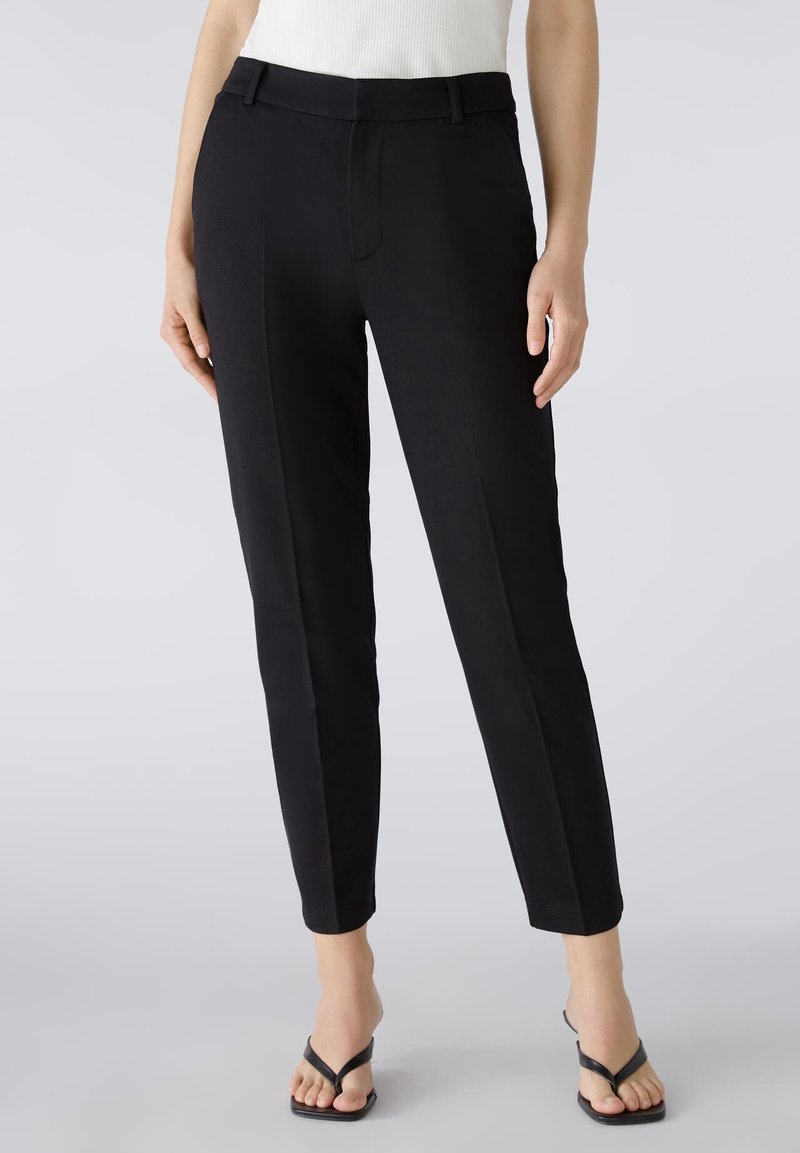 Pantalons noirs ajustés avec une texture lisse, coupe slim et poches latérales. Dotés d'une taille mi-haute et de détails de pli subtils.