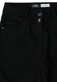 Černé džíny z denimu s klasickým pětikapsovým designem, viditelnými kovovými prvky a hladkou texturou, s nálepkou s nápisem "CECIL DENIM."