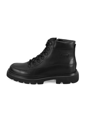 Botte de randonnée en cuir noir avec une tige haute, semelle épaisse avec des crampons profonds et un laçage à l'avant avec œillets en métal.