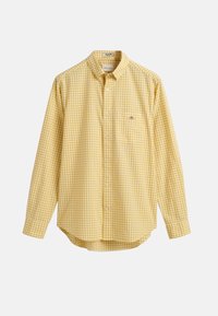 Chemise à manches longues à carreaux jaunes et blancs avec col et petit logo poitrine sur fond uni.