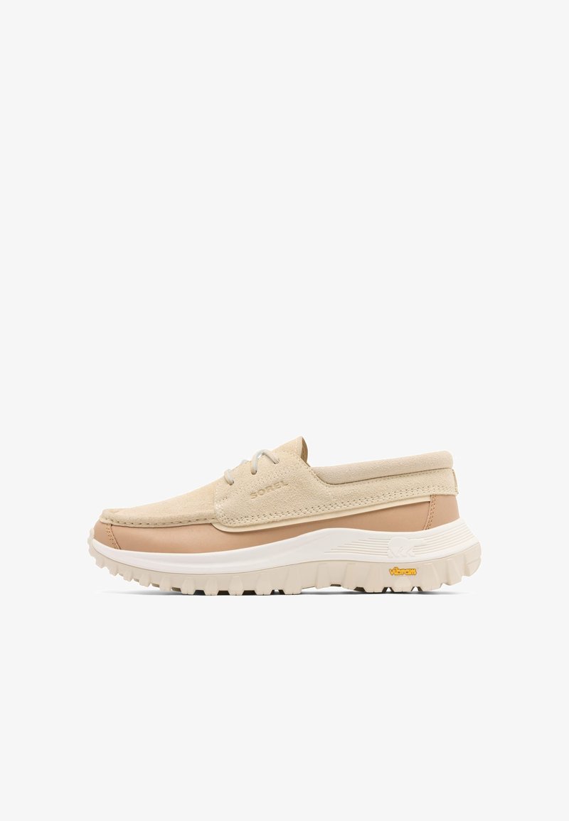 Chaussure décontractée beige et marron clair à lacets avec tige en daim, semelle blanche épaisse et bande de roulement Vibram, conçue pour une utilisation en extérieur et au quotidien.