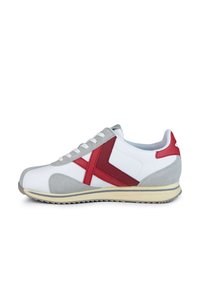 Zapatilla blanca con acentos rojos y grises. Diseño clásico, con una parte delantera de ante, rayas laterales de cuero y suela de goma. Cierre con cordones.