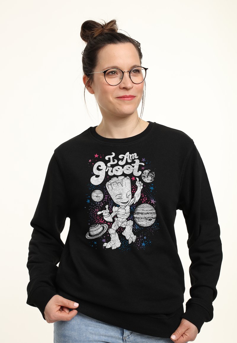 Sudadera negra con un gráfico de un personaje de dibujos animados rodeado de planetas y estrellas con el texto "Yo soy Groot" en letras negritas.
