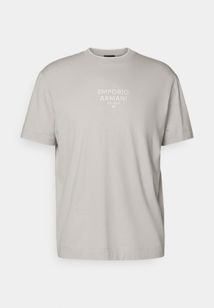 Vaaleanharmaa lyhythihainen t-paita, jossa on valkoisella painettu "EMPORIO ARMANI MILANO" keskellä rintaa.