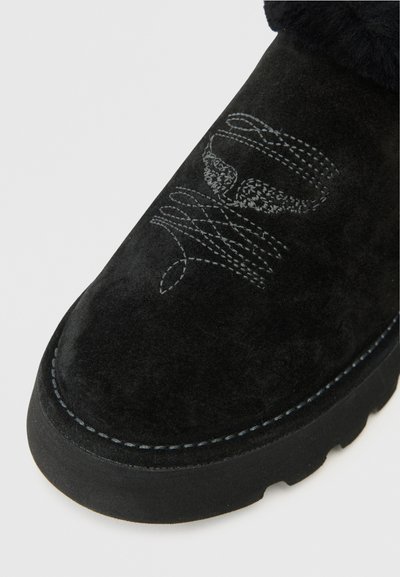 Czarne zamszowe botki za kostkę z grubą czarną gumową podeszwą, zdobione szarym haftem i widocznym przeszyciem na krawędzi.