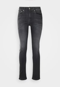 Jeans de mezclilla en gris oscuro con corte recto. Presentan cinco bolsillos, un cierre de botón y sutiles patrones de desvanecimiento en la tela.