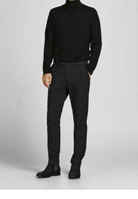 Black turtleneck sweater, fitted design. Black checkered trousers with a belt, paired with black ankle boots. Textured fabric, tailored fit.