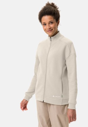 Sweatshirt zippé gris clair en tissu texturé. Il présente un col montant, des poignets côtelés et un petit logo en bas à gauche.