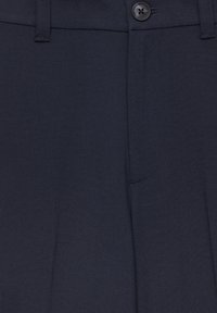 Pantalon bleu marine en tissu lisse, doté d'une fermeture à boutons à l'avant, de passants pour ceinture et d'un pli discret sur le devant.