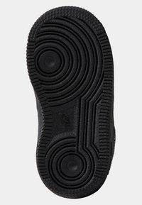 Svart gummisula med cirkelformade och vågiga mönster för grepp, med två cirkulära indragningar för extra grepp och stabilitet.