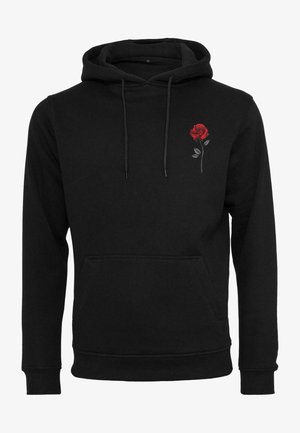 Musta kapuutsiga dressipluus pehmest materjalist, mille vasakul rinnal on väike punane roosi tikand ja ees suur tasku.