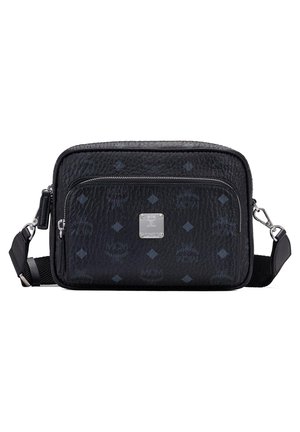 Sac bandoulière en cuir noir avec des motifs en relief et des accessoires en argent. Il dispose d'une poche zippée à l'avant et d'une sangle réglable pour plus de praticité.
