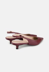 Pantofi slingback din piele bordeaux cu vârf ascuțit, toc mic și curea ajustabilă. Textură netedă cu un design minimalist.