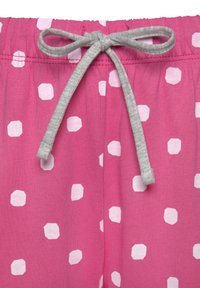 Pink pajama shorts with a soft texture, featuring white hexagonal polka dots and a grey drawstring at the elastic waistband.