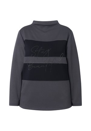 Grå og sort langærmet top med en mock krave, som har en glitrende "Stay Beautiful" tekst i kursiv over ryggen. Materiale i bomuldsblanding.