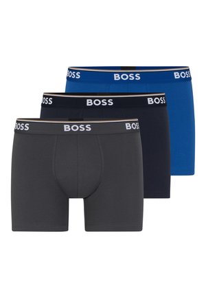 Trois paires de boxers en gris foncé, bleu marine et bleu. Chacun présente une taille douce avec le logo "BOSS" en blanc. Texture de tissu lisse.