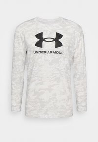 Langärmliges Shirt mit einem hellgrauen Camouflage-Muster, aus weichem Stoff gefertigt. Mit schwarzem Under Armour-Logo über der Brust.