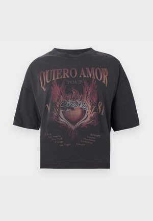 Μαύρο cropped t-shirt με το κείμενο "Quiero Amor Tour", γραφικό με φλεγόμενη καρδιά και λίστα πόλεων των ΗΠΑ και της Ευρώπης από κάτω.