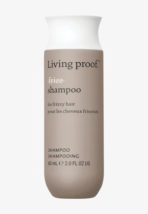 Living Proof -shampoopullo, joka on merkitty kiharoille hiuksille, beige valkoisella kannella, koko 60 ml (2,0 fl oz), kaksikielinen teksti englanniksi ja ranskaksi.