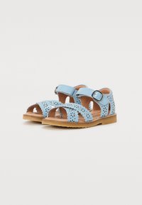 Sandales bleu clair avec des motifs floraux découpés, sangle réglable avec boucle et semelle texturée marron. Conception ouverte pour la respirabilité.