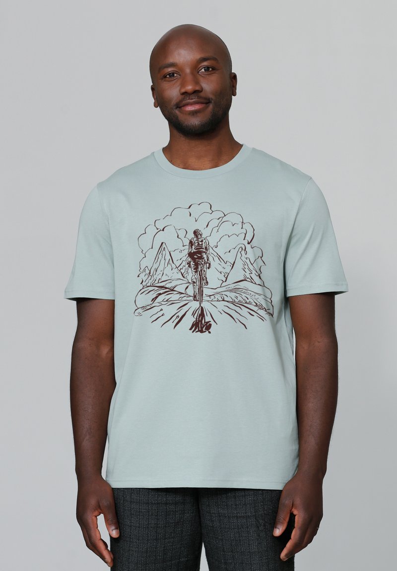 Licht mintgroene katoenen t-shirt met een bruine grafische ontwerp van een fietser en bergen. Korte mouwen en een ronde halslijn.