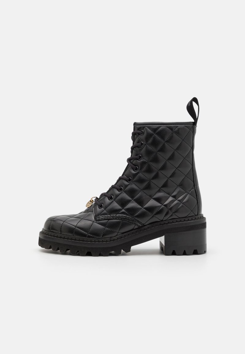 Botte de cheville en cuir noir matelassé avec un bout rond, à lacets à l'avant, semelle épaisse et talon épais. Comprend une languette et un accent doré.