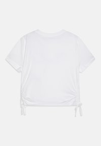 Lühikeste varrukatega valge T-särk, millel on ümar kaelus ja kokku kogutud külgse seams, millel on reguleeritavad sidemed, et kohandada sobivust.