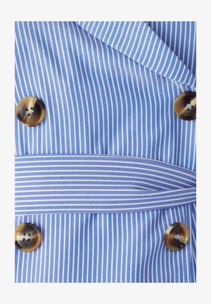 Chaqueta de doble botonadura con rayas verticales en azul y blanco. Presenta botones marrones y un cinturón a juego hecho del mismo tejido.