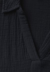 Dunkelblaues, strukturiertes Gewebe mit einem subtilen Rasternmuster, das einen Kragen und überschneidende Vorderteile aufweist, für ein leichtes Kleidungsdesign.