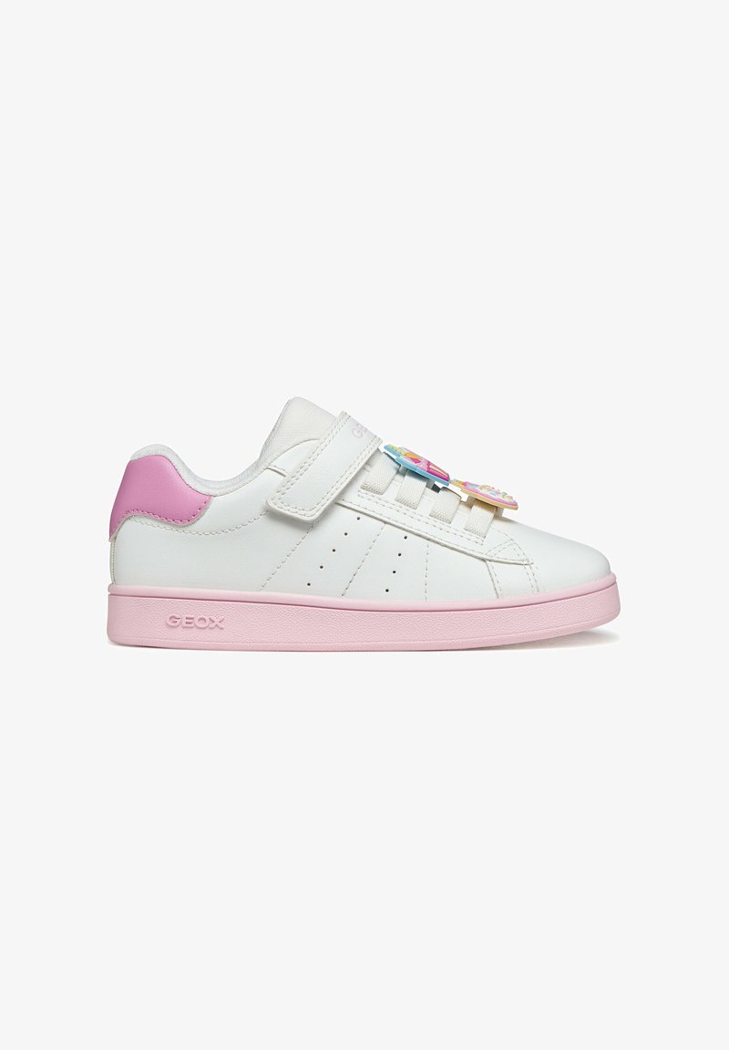 Zapatilla blanca para niños con suela y talón rosa, cierre de velcro y dijes decorativos coloridos en los cordones, vista lateral.