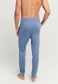 Blauwe loungebroeken gemaakt van zachte stof, met een elastische tailleband, zijzakken en een relaxte pasvorm, met een soepele textuur.