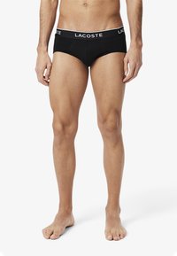 Zwarte katoenen slips met een witte Lacoste-logo tailleband. Het ontwerp heeft een aansluitende pasvorm en minimale naden voor comfort.