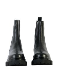 Bottes de cheville en cuir noir, avec une finition lisse, des panneaux latéraux élastiques et des semelles en caoutchouc robustes. Présentent une languette à l'arrière.