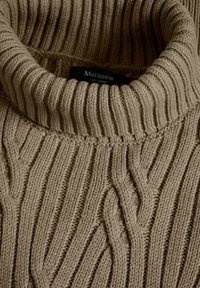 Beige kötött turtleneck pulóver 100% merinói gyapjúból, függőleges bordázott textúrával és puha, vastag fonallal.
