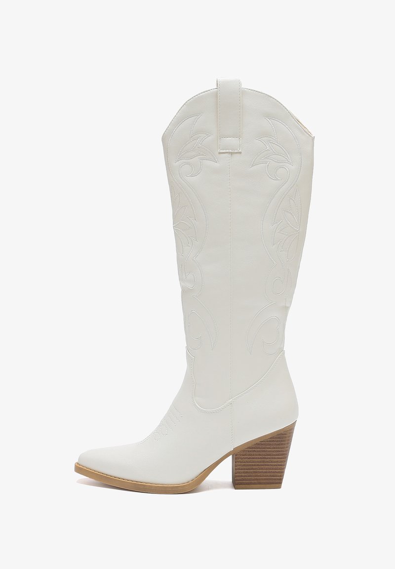 Białe skórzane kowbojki z wąskim noskiem, haftowanym kwiatowym wzorem i podniesioną drewnianą piętą. Posiadają pętelkę ułatwiającą zakładanie.