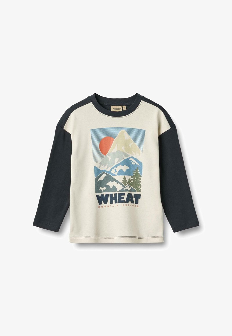 Hosszú ujjú póló, krémszínű testtel és sötét tengerészkék ujjakkal, hegyi grafikával, és a "WHEAT" szó nagybetűs felirattal az elején.