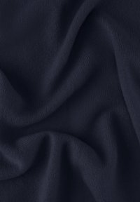 Tissu tricoté bleu foncé, doux, avec une texture lisse et un léger élasticité, présentant de légères vagues et plis sur toute la surface.