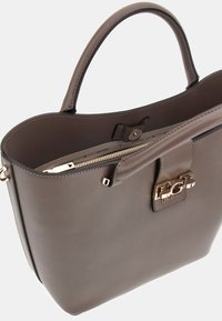 Bolso de mano de cuero marrón con asas dobles, bolsillo con cremallera, herrajes en tono dorado y una textura suave. El interior muestra el logo y detalles de costura.