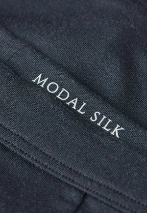 Dunkles Gewebe mit einem tief sitzenden Bund, auf dem "MODAL SILK" in Weiß gedruckt ist. Glatte Textur, dehnbares Material für Komfort.