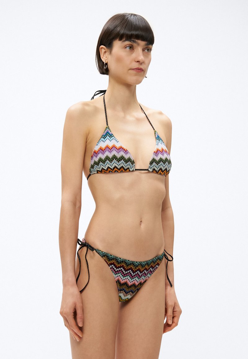 Bikini-Set im mehrfarbigen Zickzackmuster. Triangel-Top mit verstellbaren Halsbändern und passende Hose mit seitlichen Bändern. Strukturierter Stoff.