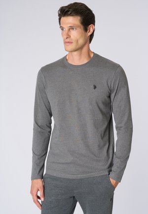 T-shirt grigio a maniche lunghe realizzato in morbido tessuto, con colletto a girocollo e un logo sottile sul petto, abbinato a pantaloni grigi coordinati.