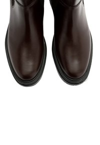 Brązowe skórzane botki na kostkę z gładkim wykończeniem, okrągłym noskiem, niskim obcasem oraz subtelnymi czarnymi akcentami i szczegółami w szyciu.