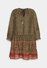 Groene bloemenjurk met lange mouwen, gestoffeerde halslijn, franjerandaccenten en een gelaagd zoom met rode en bloemachtige patronen. Halfdoorzichtige textuur.