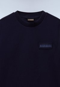 Dark navy blue crew neck sweatshirt with Napapijri logo patch on chest and matching logo tag inside neckline.