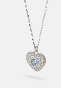 Hõbedane südamekujuline ripatsikaelakee, mille keskel on helesinine gemstone, ümbritsetud arvukate väikeste selgete gemstone'idega, mis on kinnitatud ahelale.