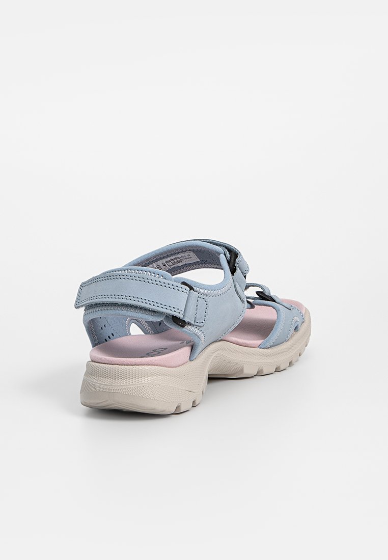 Hellblaue Sandale mit einem samtartigen Obermaterial, verstellbaren Riemen und einer klobigen beigen Sohle. Verfügt über eine gepolsterte rosa Innensohle.