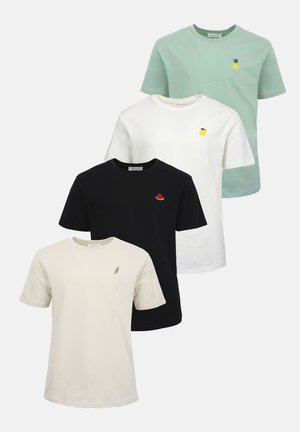 Mann steht, trägt beige kurzärmeliges T-Shirt, schwarze zerrissene Skinny-Jeans und braune Turnschuhe auf weißem Hintergrund.